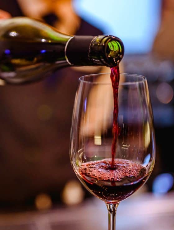pouring red wine into glass