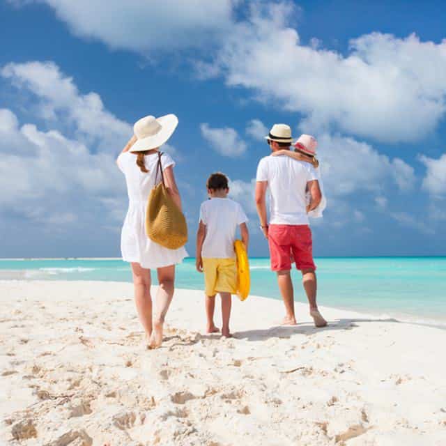 family standing on the beach
